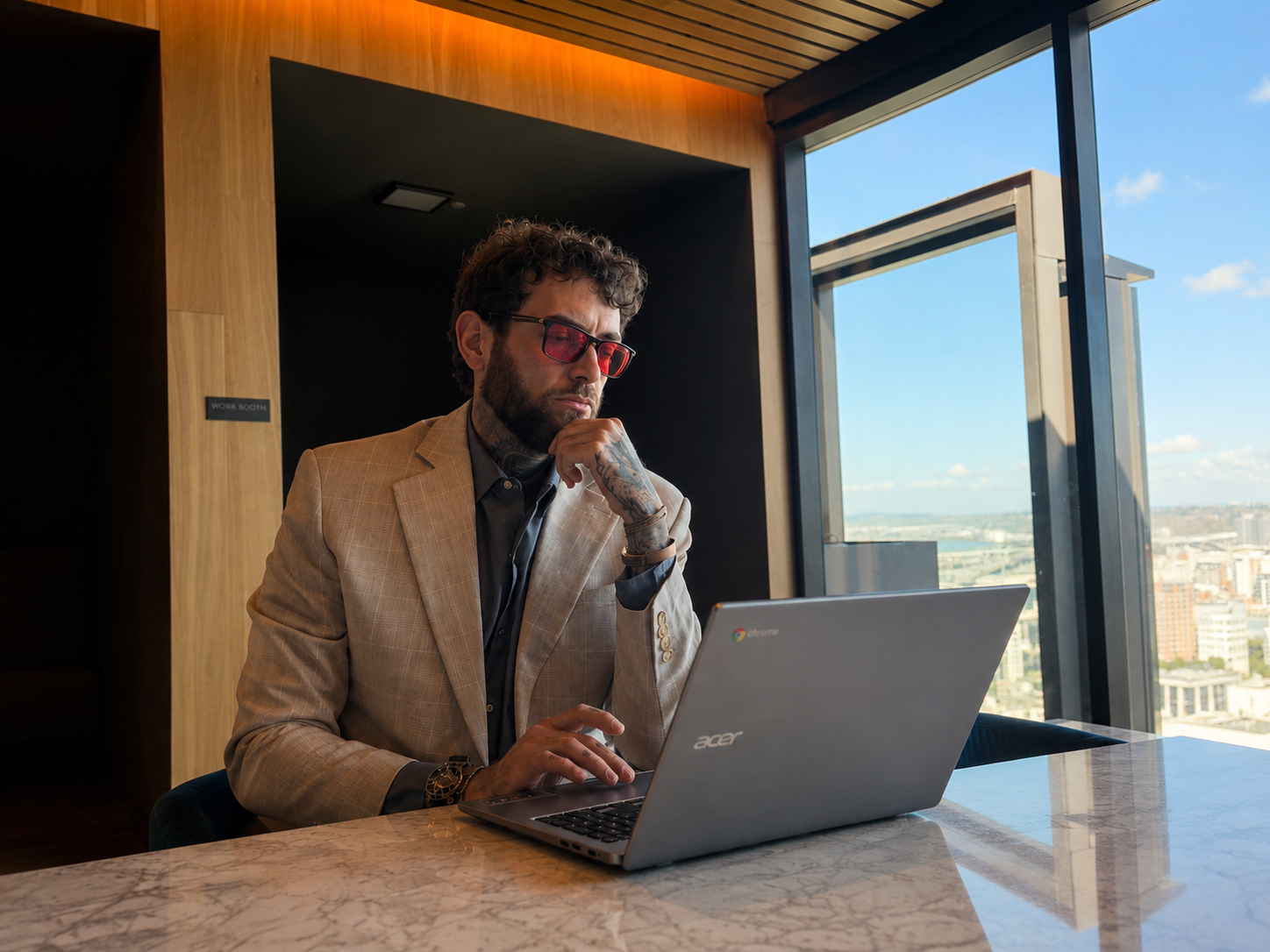 Alexander Easley working from a city-view studio booth